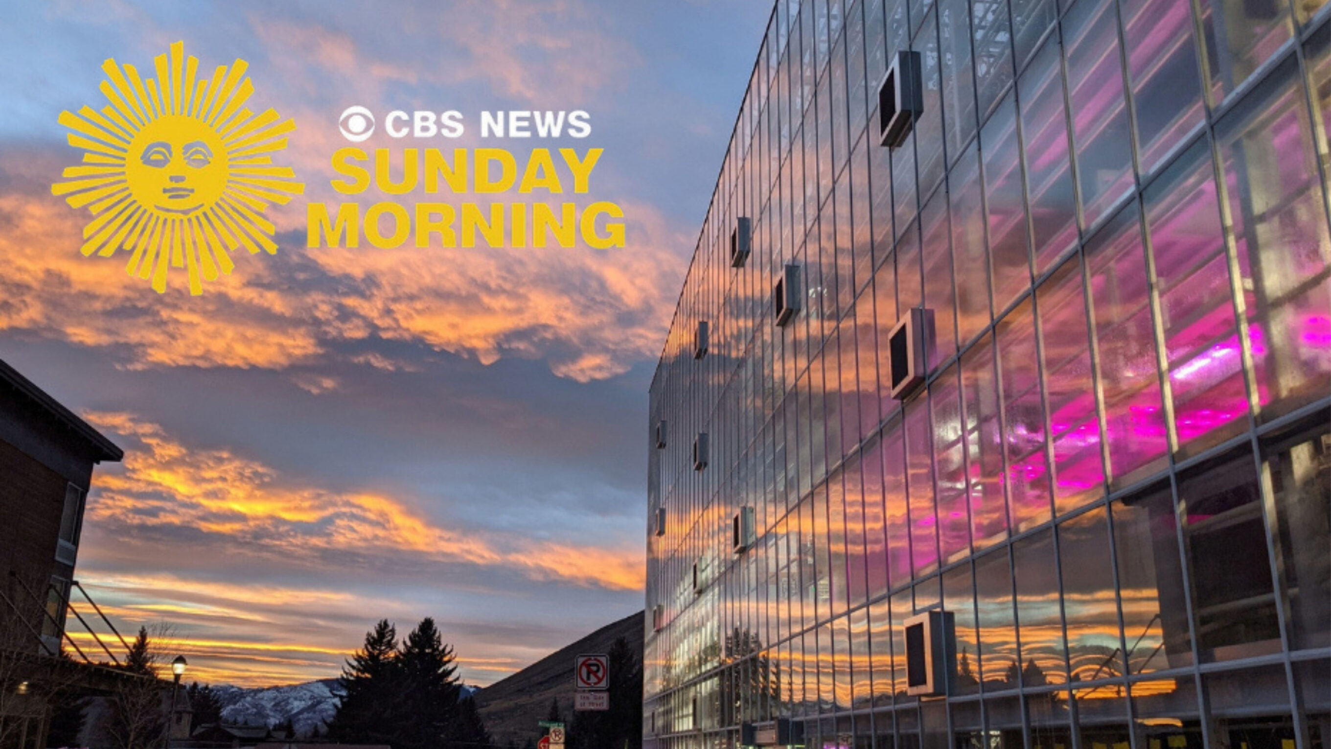 Vertical farm greenhouse with sunset reflected in it's glass exterior with a CBS Sunday Morning logo